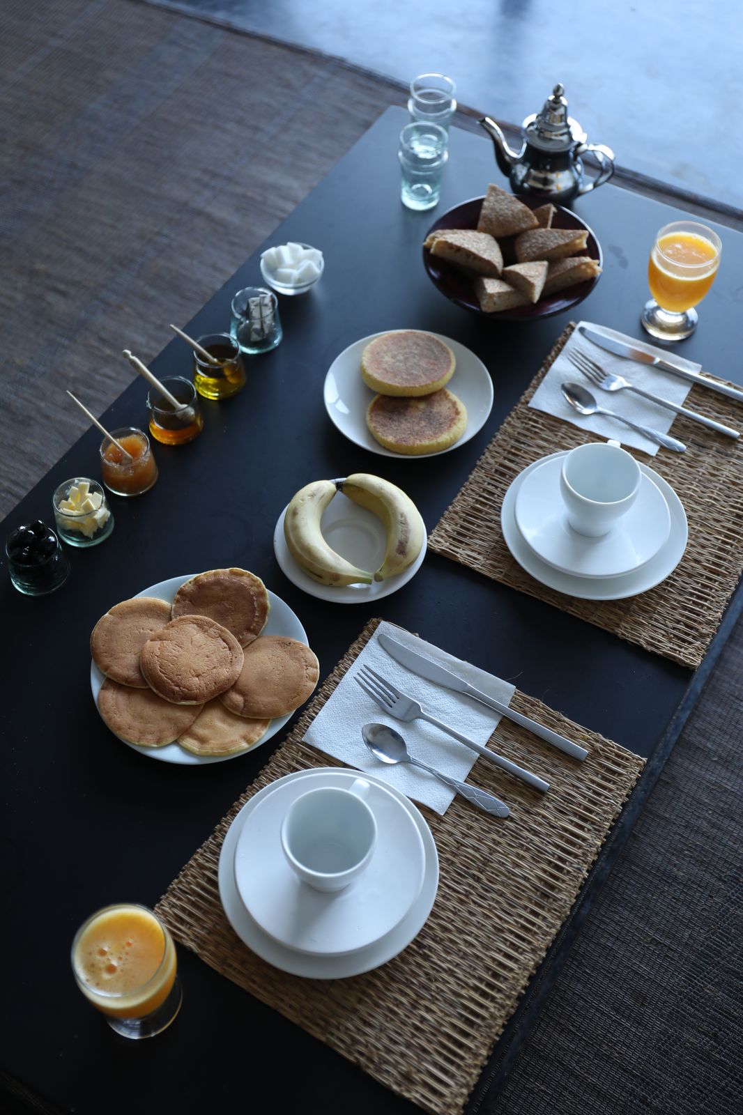 Le petit-déjeuner d'El Manzar dressé : pain, crêpes, confitures maison et thé à la menthe sur la table